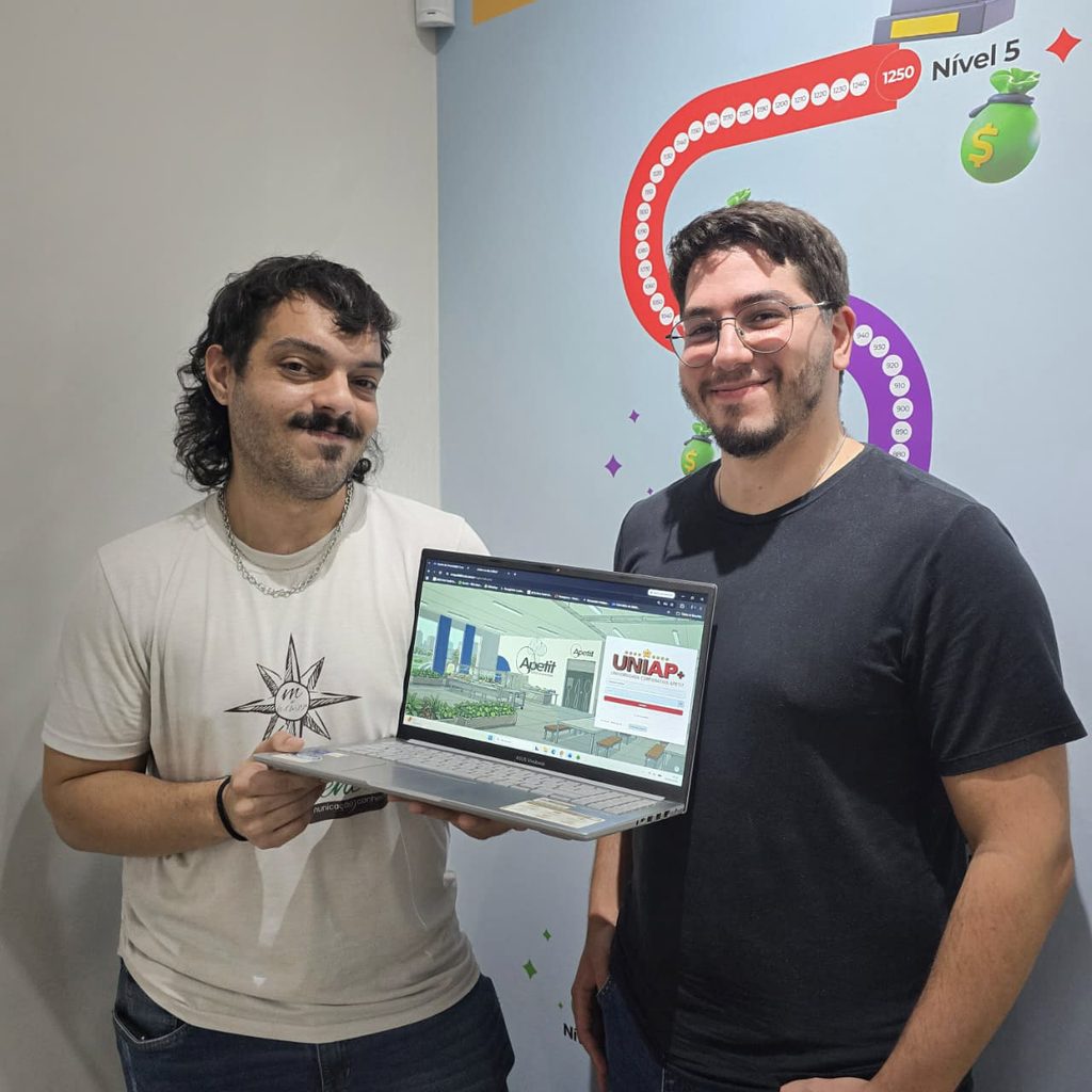 Marcus Martin e Lucca Biagini mostrando a interface da plataforma UNIAP Gamificada da Apetit mostrando trilhas de aprendizagem, Apetit Coins e Bottons de Excelência.